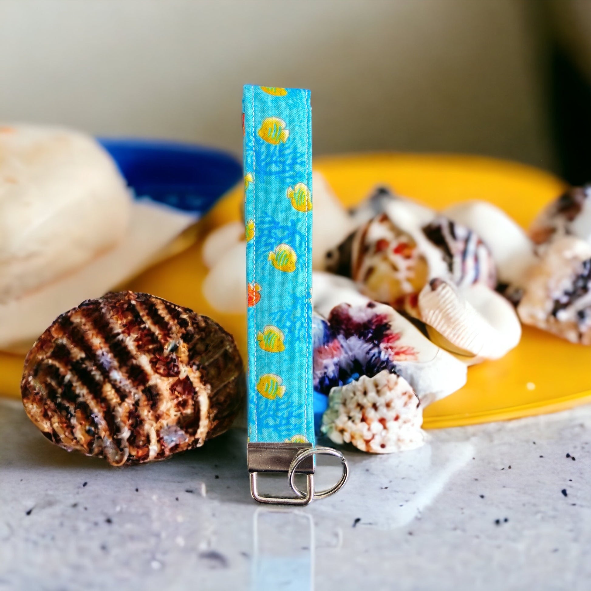 blue wristlet with yellow and orange fish with shells