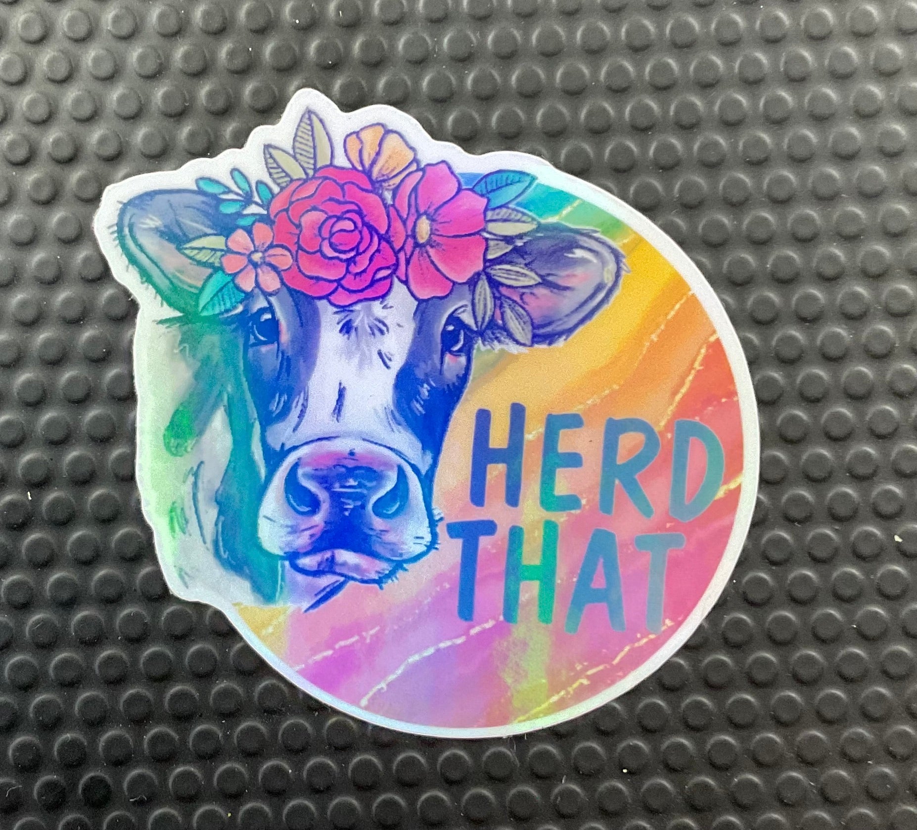cow with flowers and rainbow background. words read heard that
