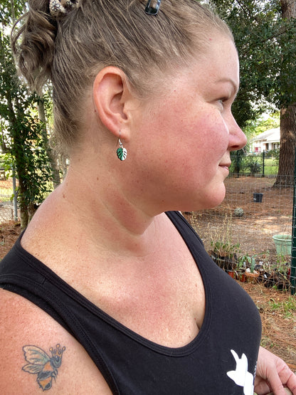 girl wearing hand painted monstera earrings