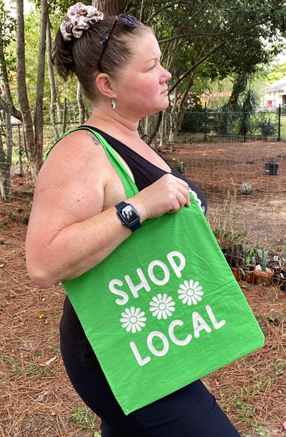 woman holding green and white shop local tote bag