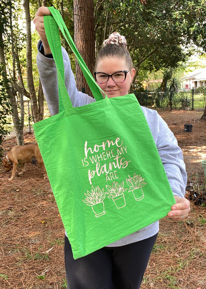 Green totebag that reads home is where my plants are