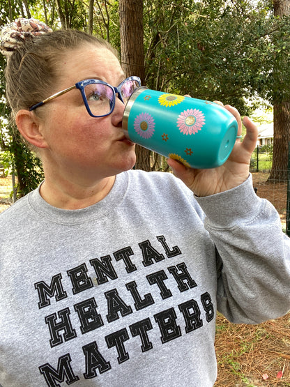 girl drinking from blue flower tumbler