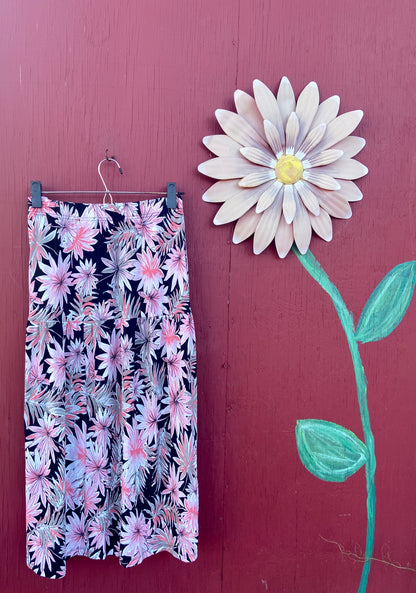 pink, black, and white flower skirt next to a pink daisy