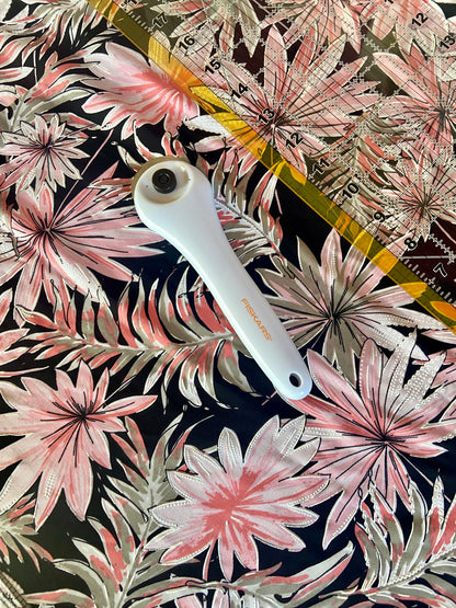 pink, black, and white marble fabric with rotary cutter and measuring tool