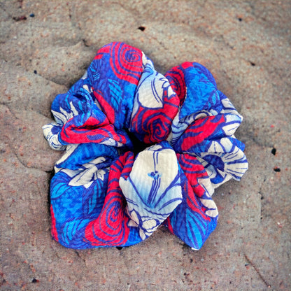 red, white, and blue floral scrunchie on sand