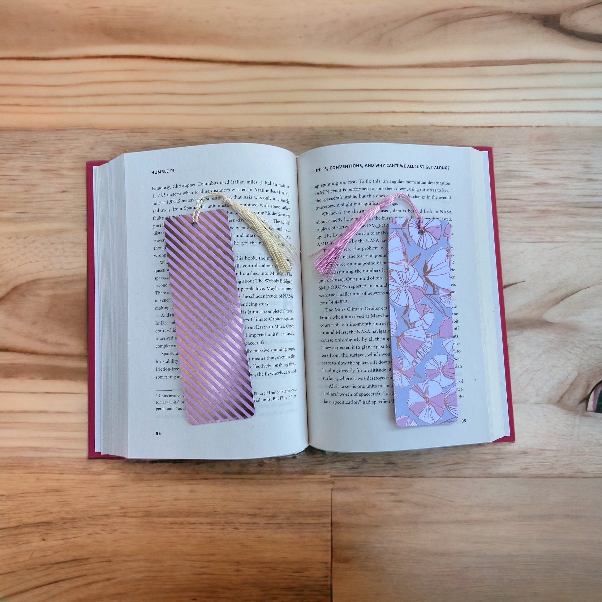 two pink and gold bookmarks on a book