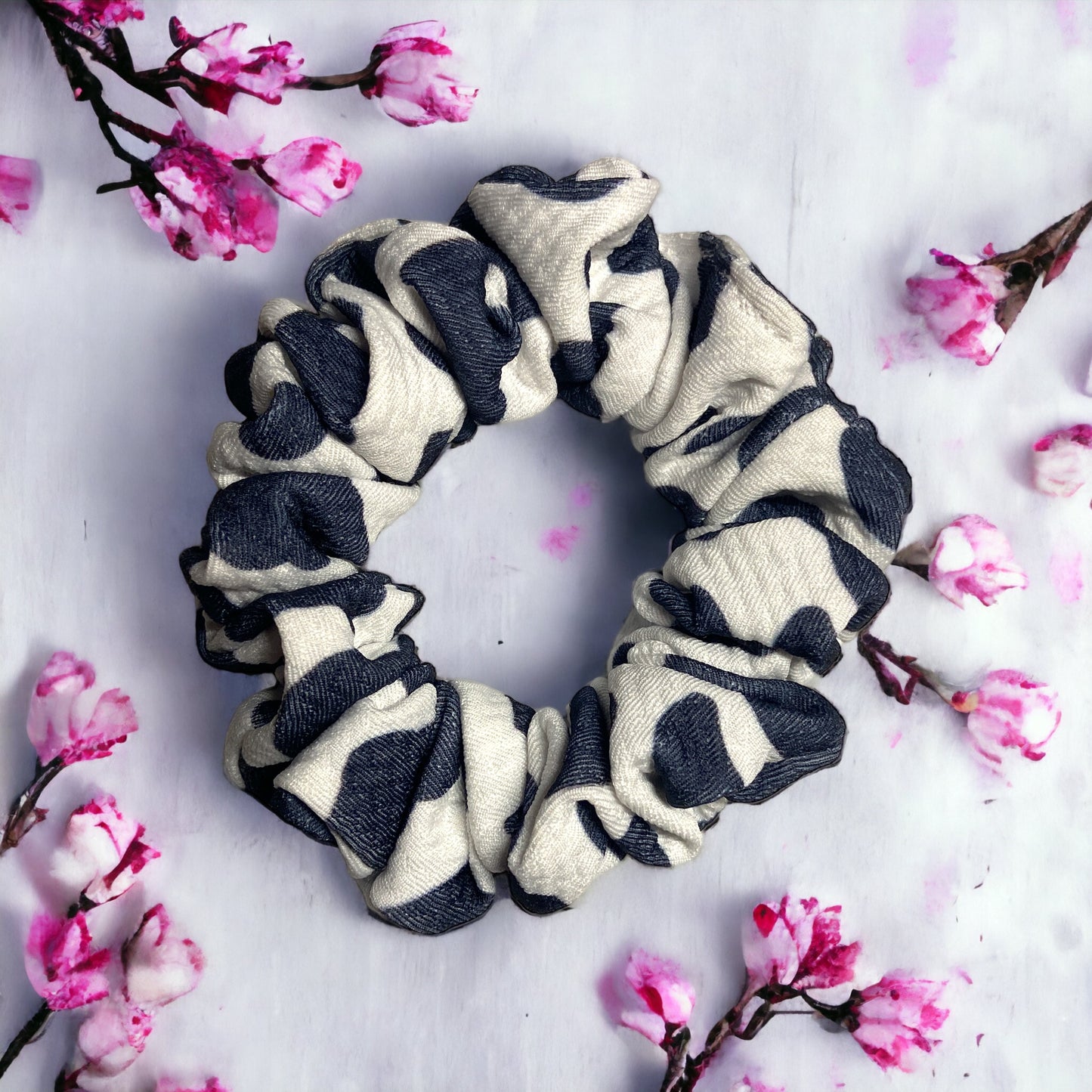 cow scrunchies on white background and pink flowers