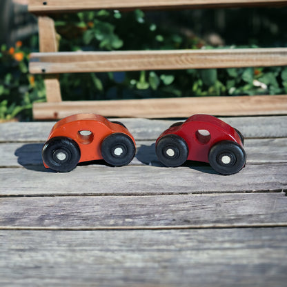 two painted wooded cars on wood