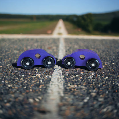 two purple wooden cars on street