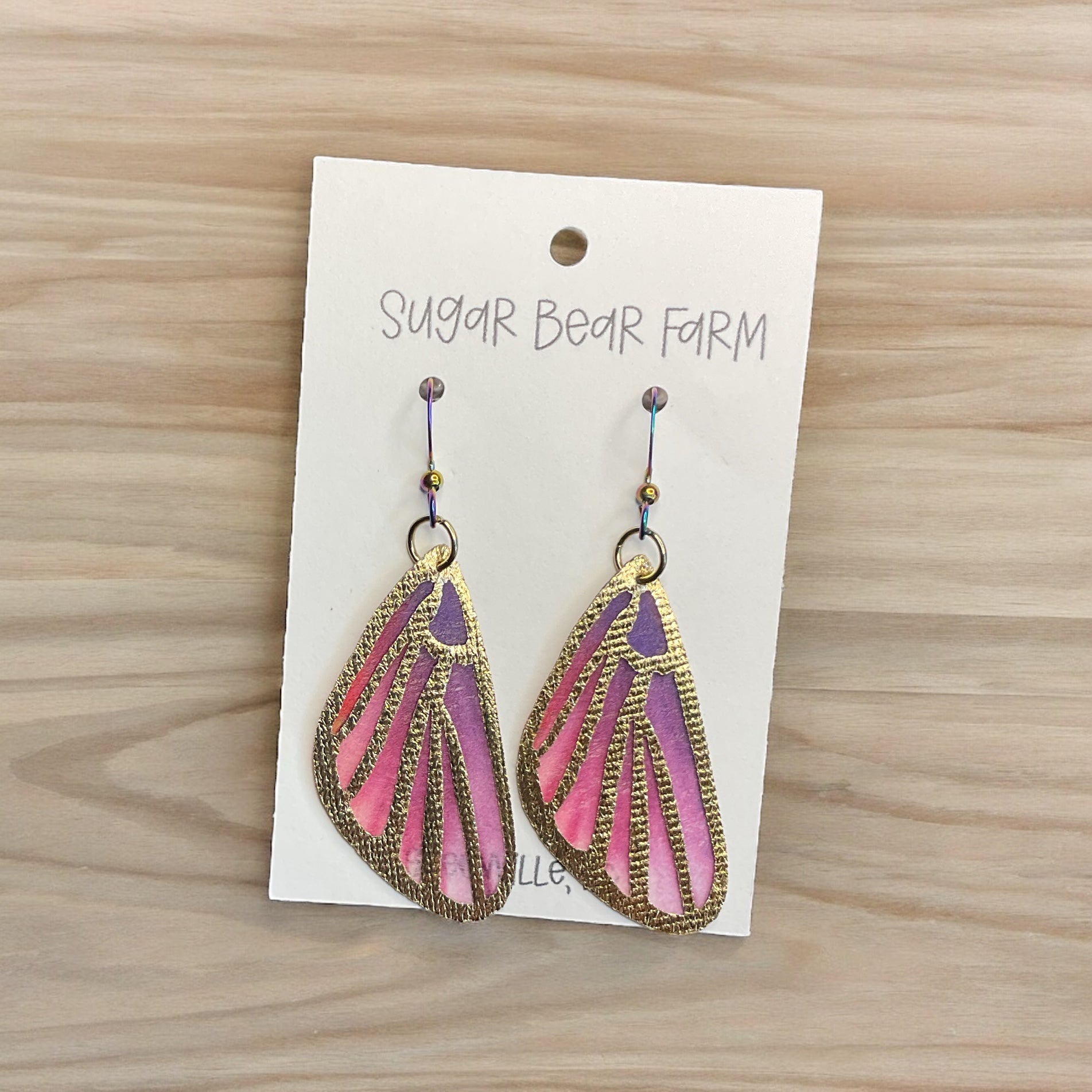 pink butterfly earrings on wood