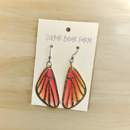 orange butterfly earrings on wood