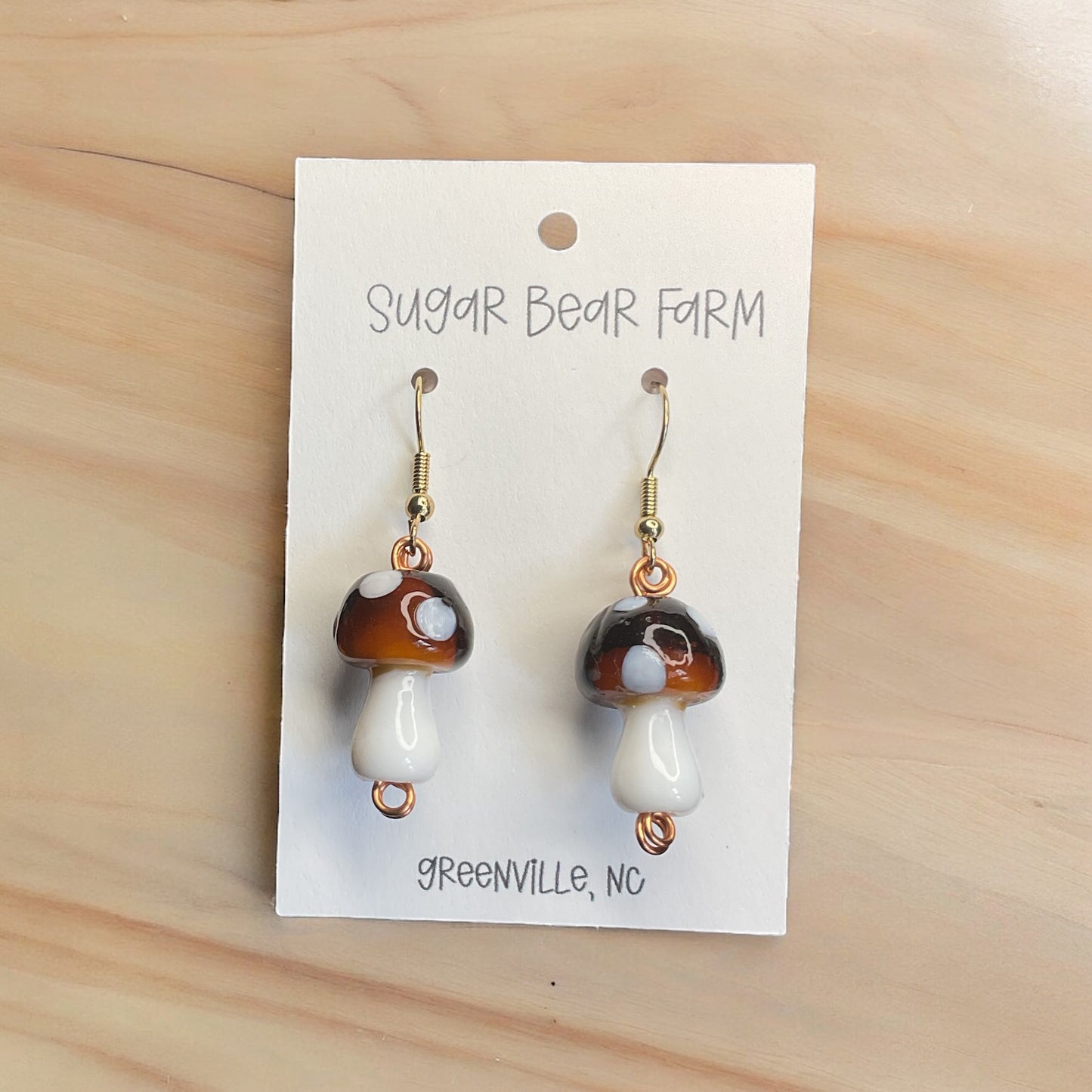 pair of brown and white glass mushroom earrings