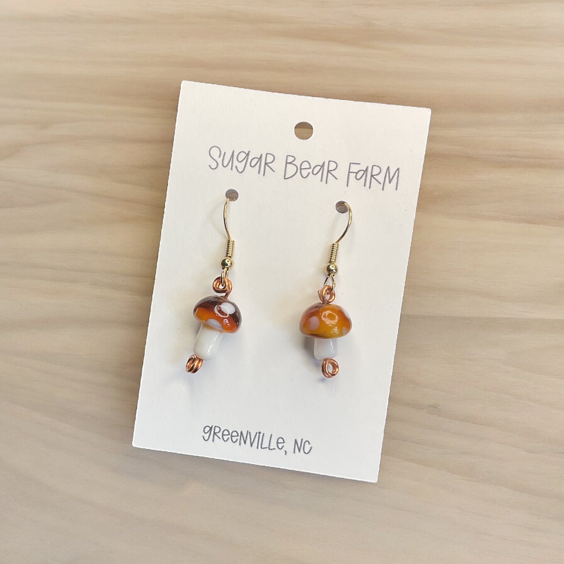 pair of brown and white glass mushroom earrings