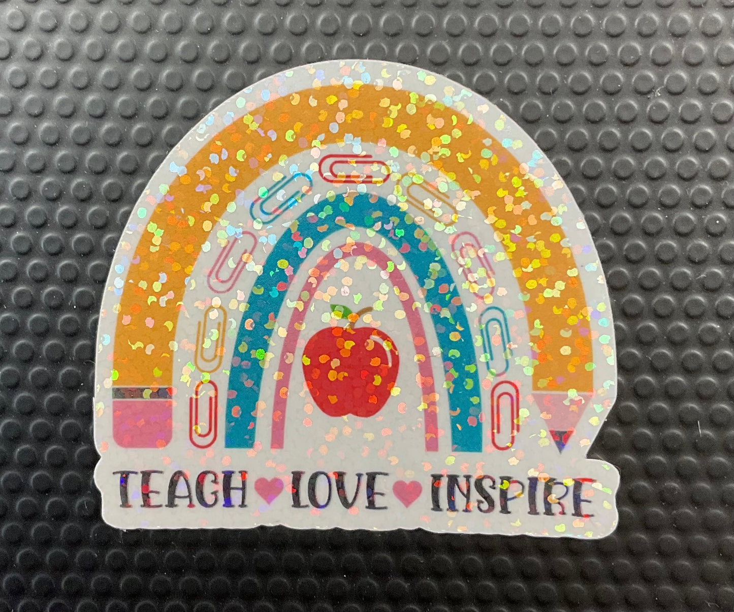 Pencil rainbow sticker with the words teacher love inspire