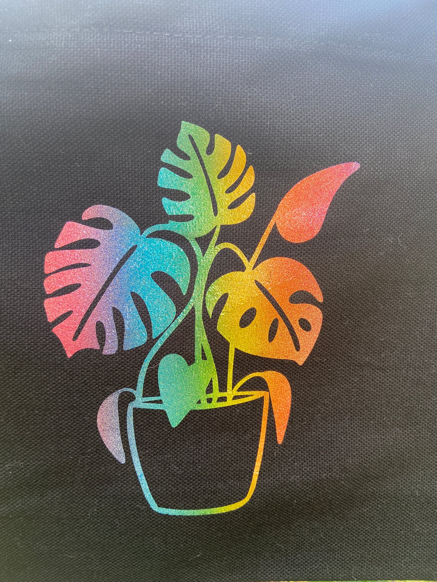 shimmer rainbow monstera on a black tote bag