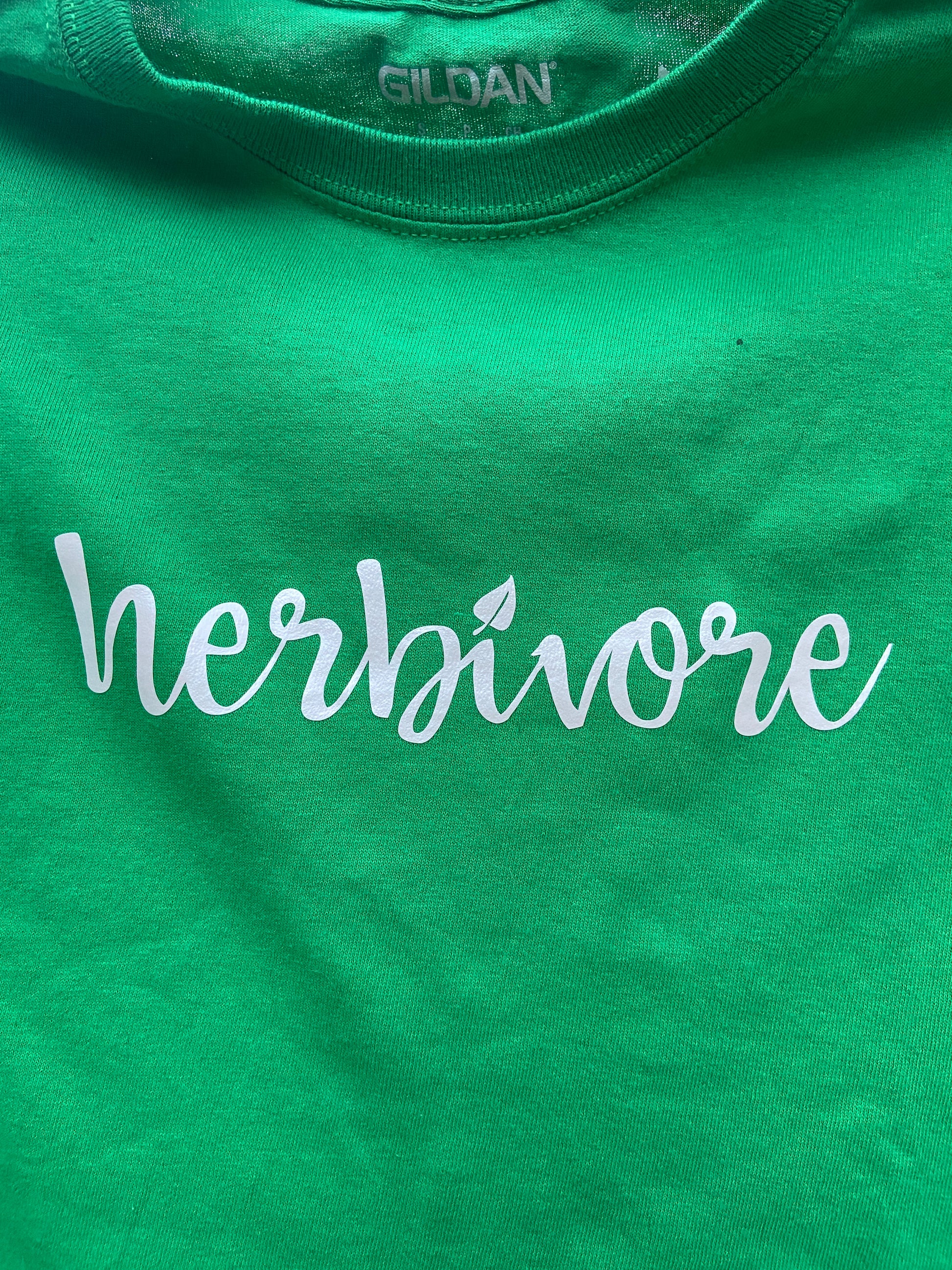 words herbivore in white on a green shirt